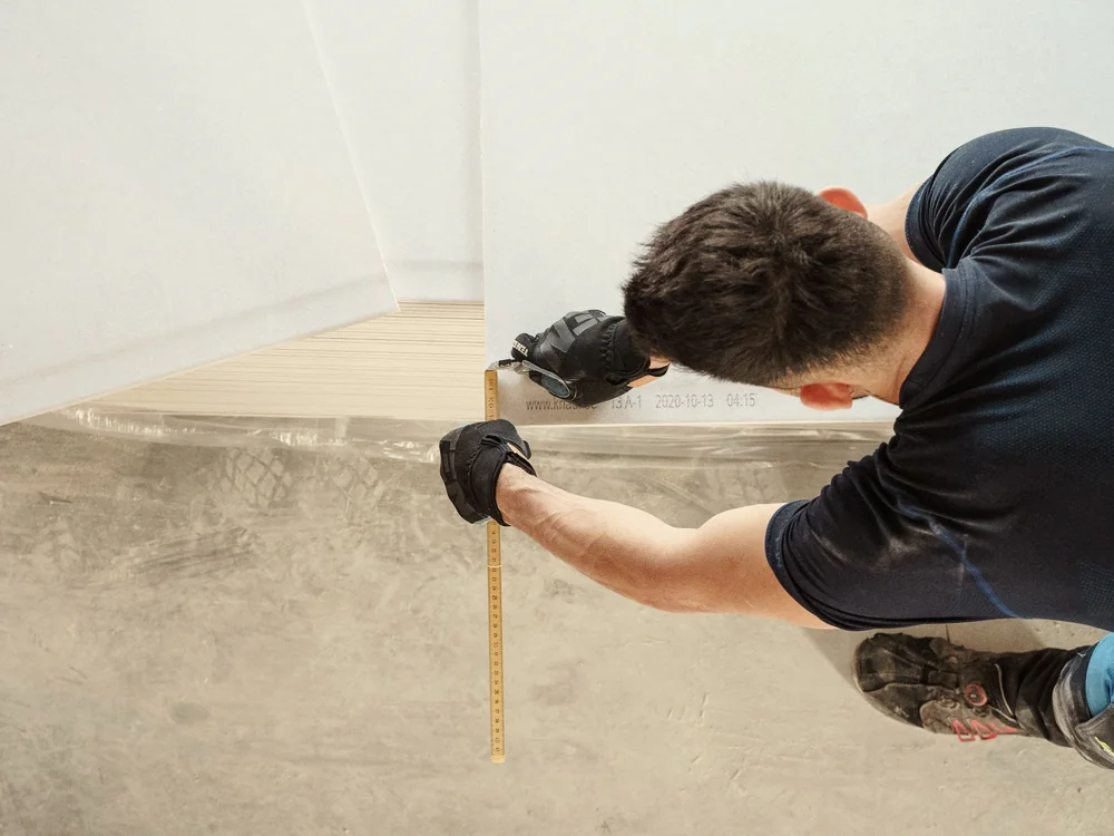 Vakman meet hout op met een rolmaat